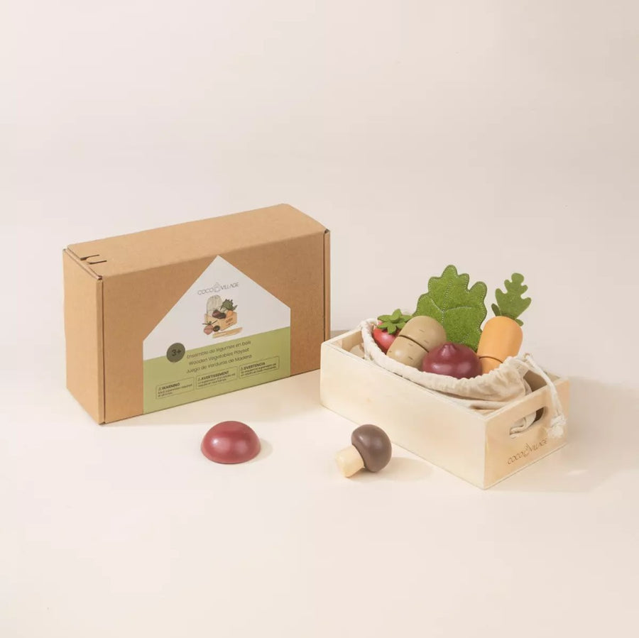 Picture shows the wooden veggies, cloth bag, and crate alongside their packaging box which is natural kraft color with a green and white label