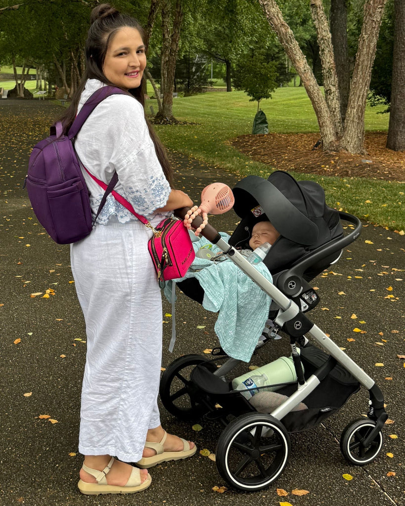 Woman pushing a stroller with a baby in a park