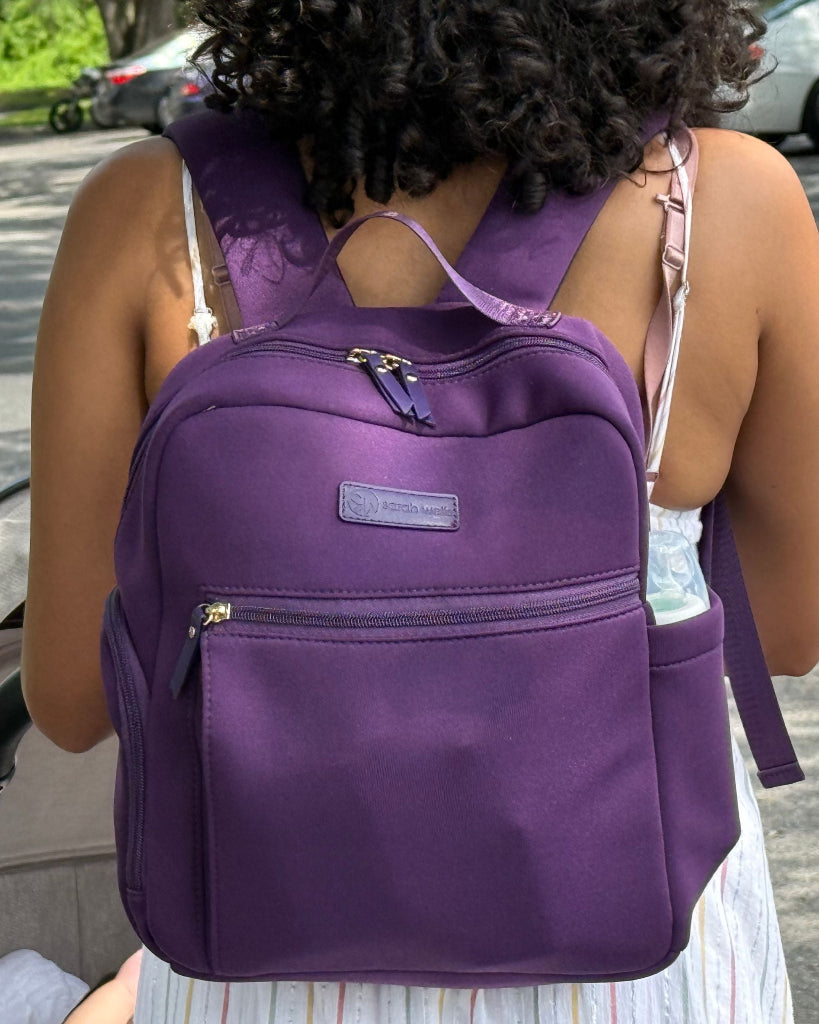 Person wearing a purple backpack outdoors