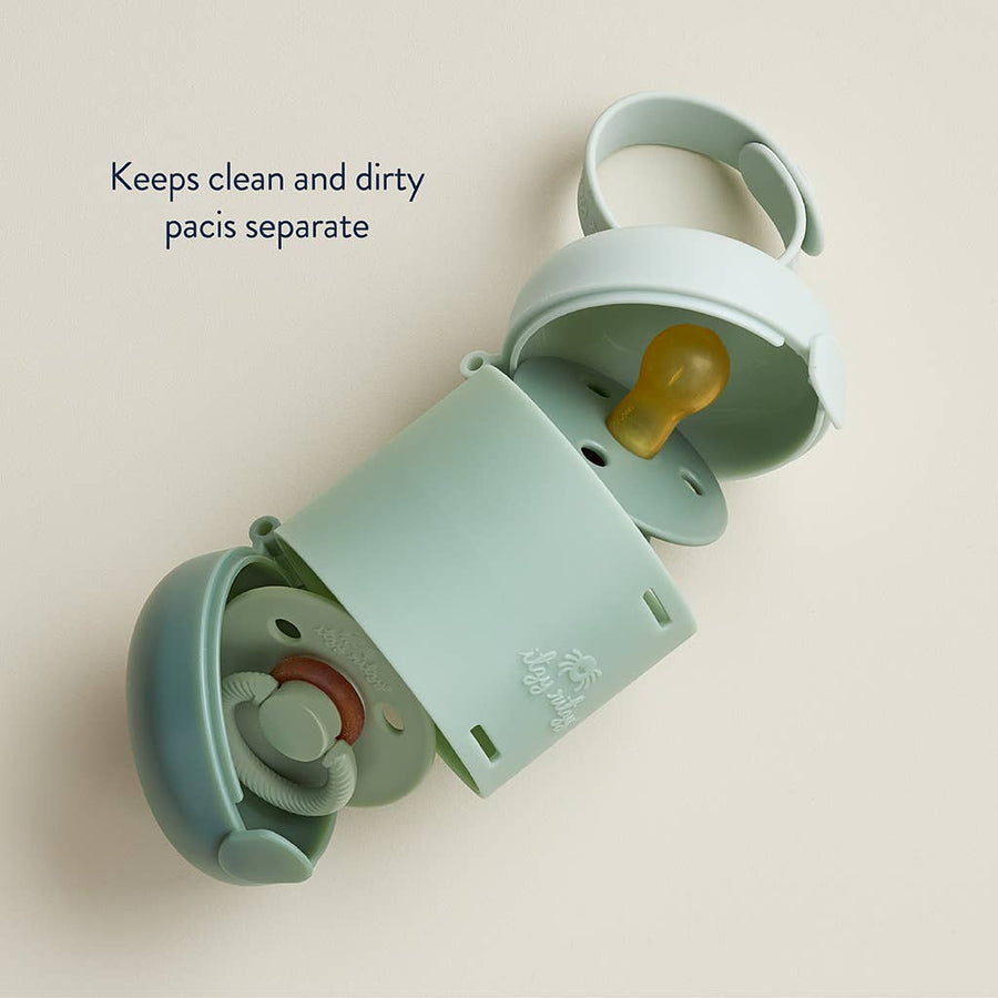 Mint green pacifier case with two pacifiers inside on a beige background