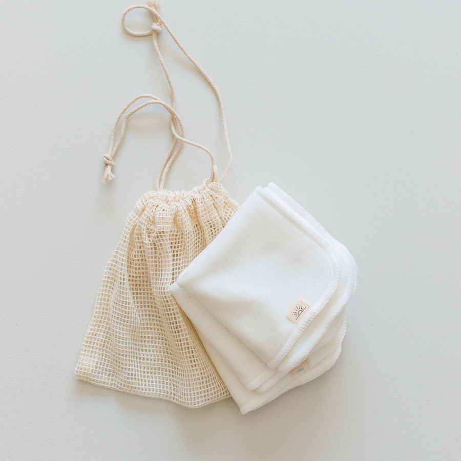 Beige drawstring bag with a white towel on a light gray background
