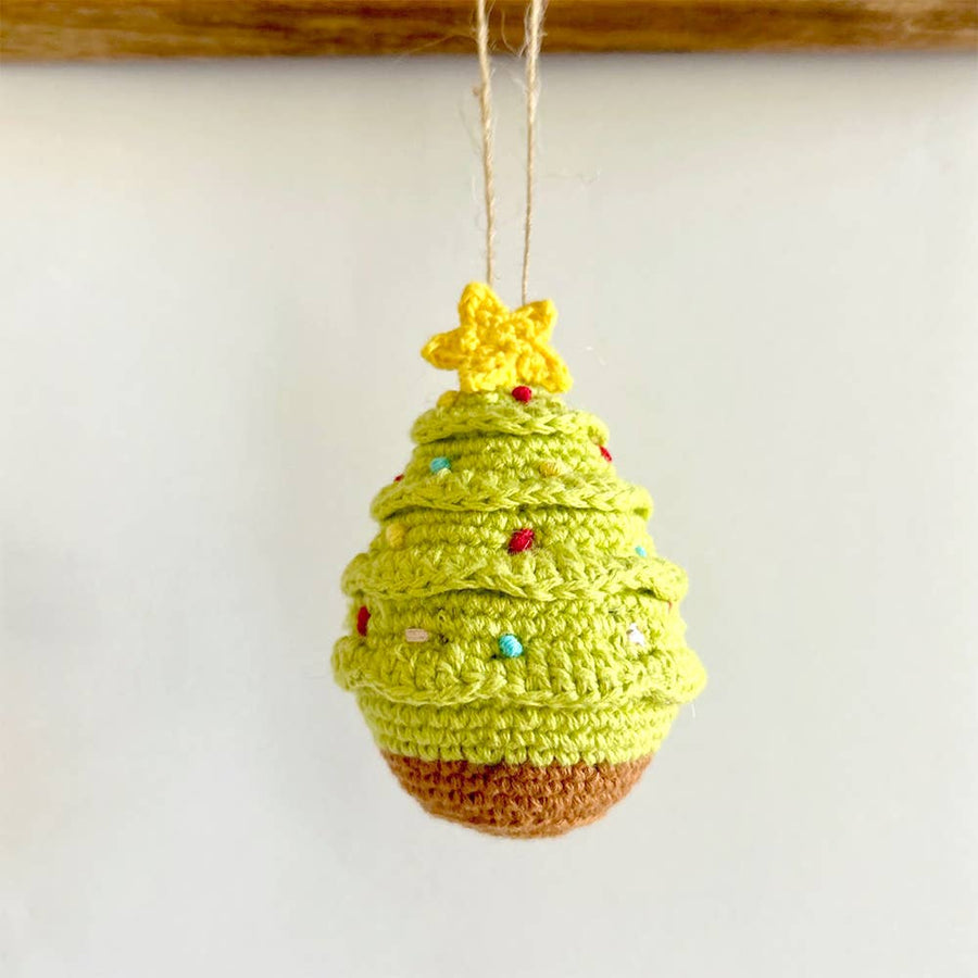 Crocheted Christmas tree ornament with a star on a white background