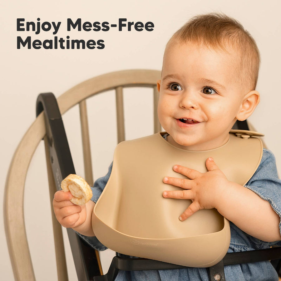 Child wearing a beige bib with text 'Enjoy Mess-Free Mealtimes' on a beige background