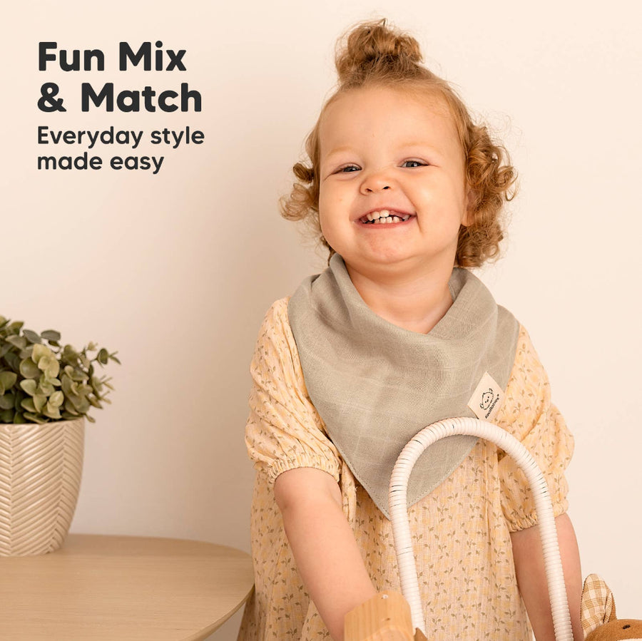 Child wearing a gray bib with text 'Fun Mix & Match Everyday style made easy' on a beige background