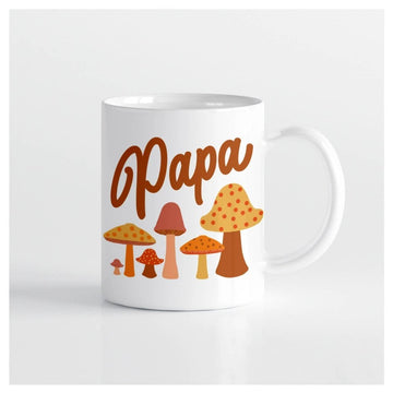 Image of the mug against a white background. It is white, with the word Papa in reddish orange cursive script above a variety of cute mushrooms
