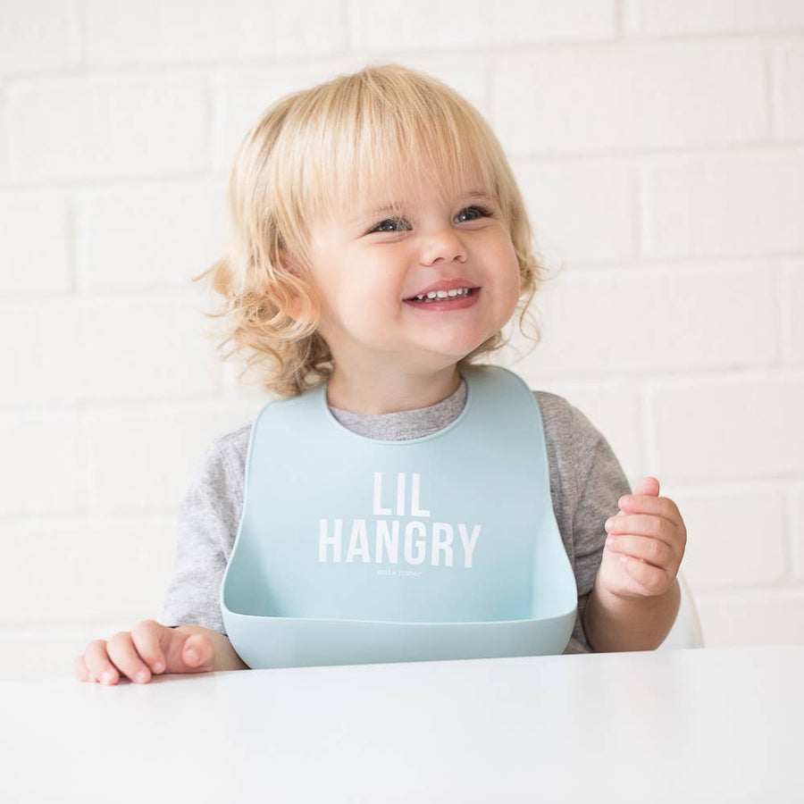 Child wearing a light blue bib with 'LIL HANGRY' text on a white background