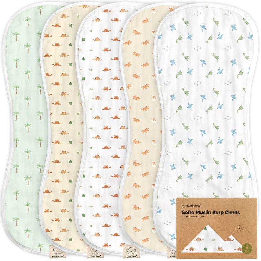 Set of four soft muslin burp cloths with different patterns on a white background.
