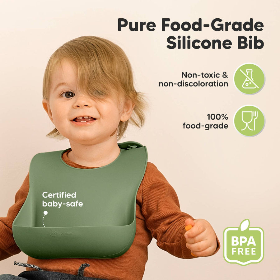 Child wearing a green silicone bib with certification text on a beige background