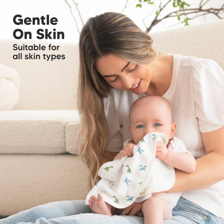 Woman holding a baby wrapped in a blanket with text 'Gentle On Skin Suitable for all skin types' on a light background