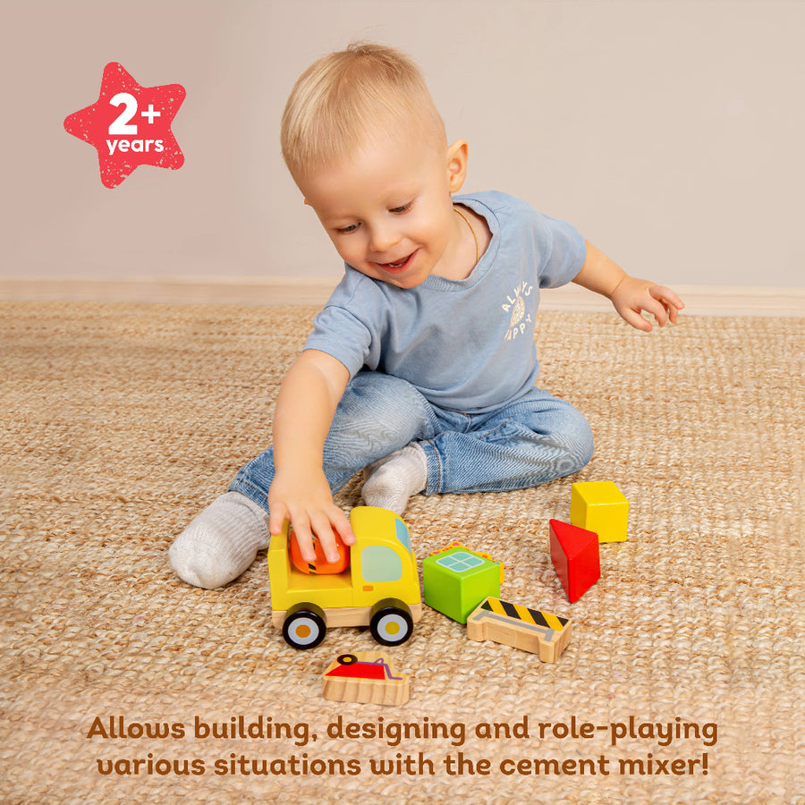 Child playing with wooden toy cement mixer on a carpeted floor