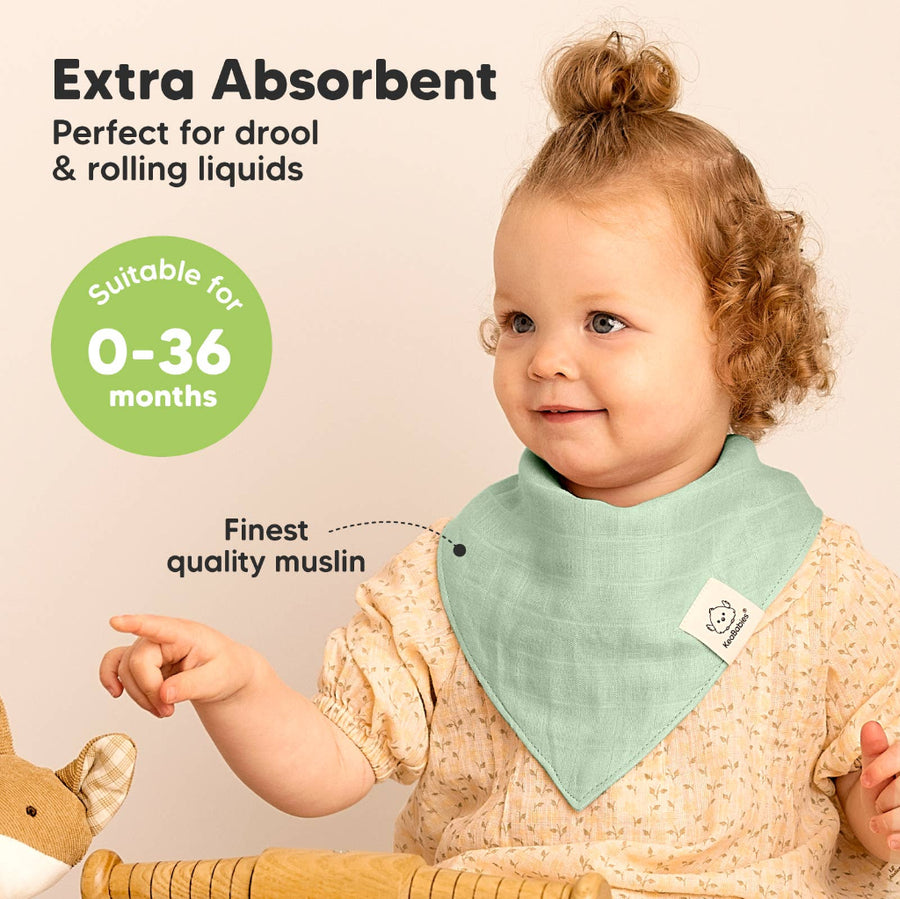 Child wearing a green bib with text about absorbency and age suitability on a beige background
