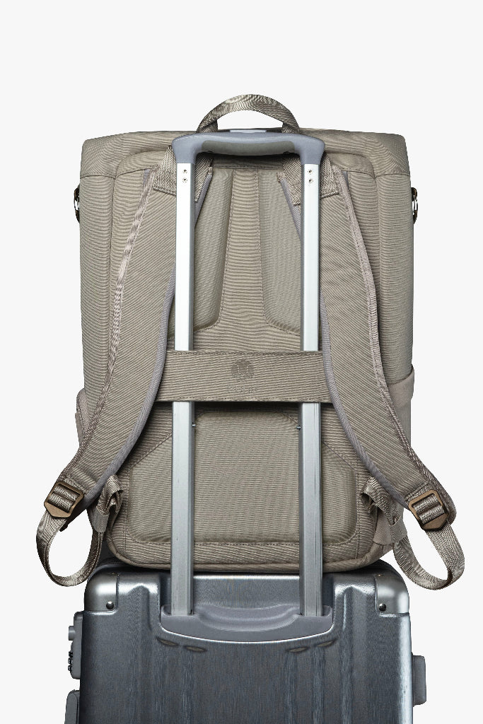 Backpack with rolling handle attached to a suitcase on a white background