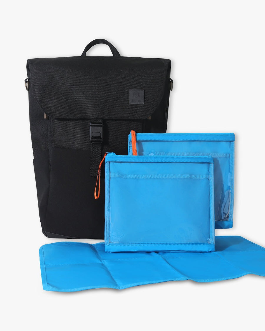Picture of a front view of the black backpack with the open blue changing pad and two blue zipper pockets in front of it