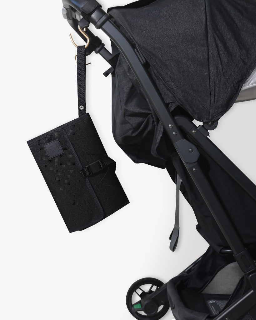 Picture of a black stroller with the black changing wallet hanging from a stroller hook