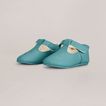 Pair of teal baby shoes on a light gray background