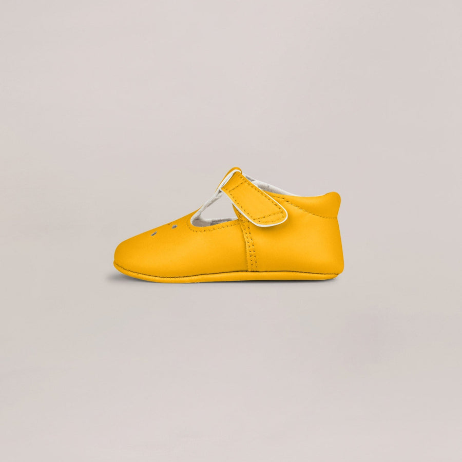 Yellow baby shoe on a light gray background