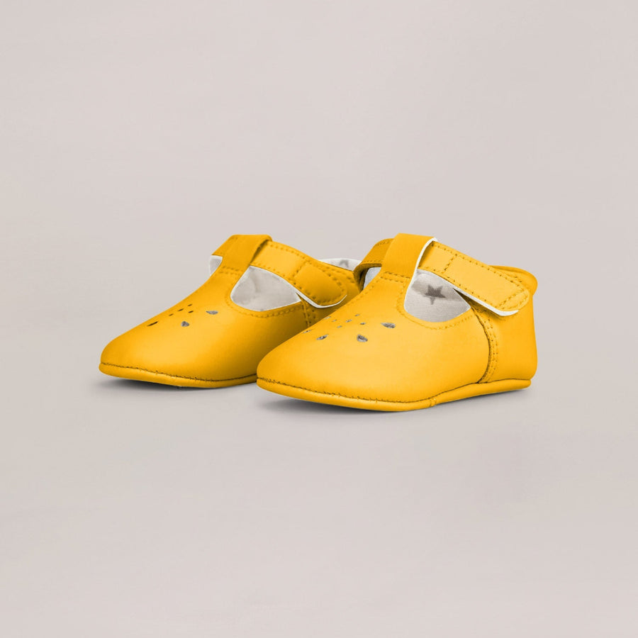 Pair of yellow shoes on a light gray background