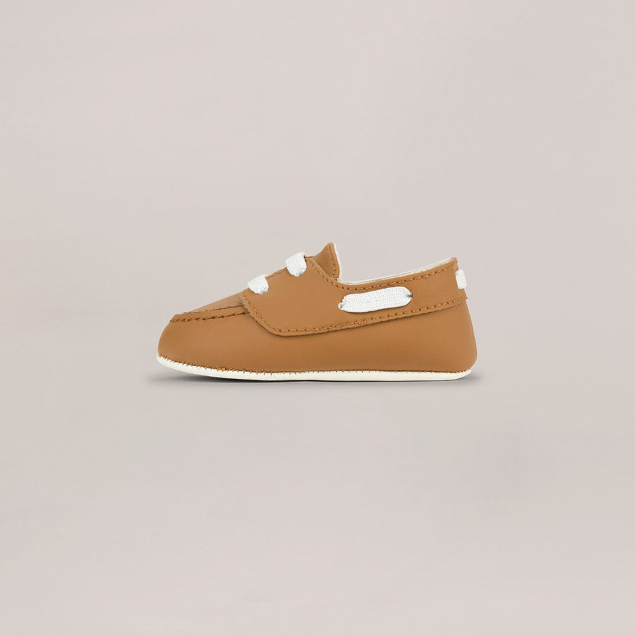 Brown baby shoe on a light gray background