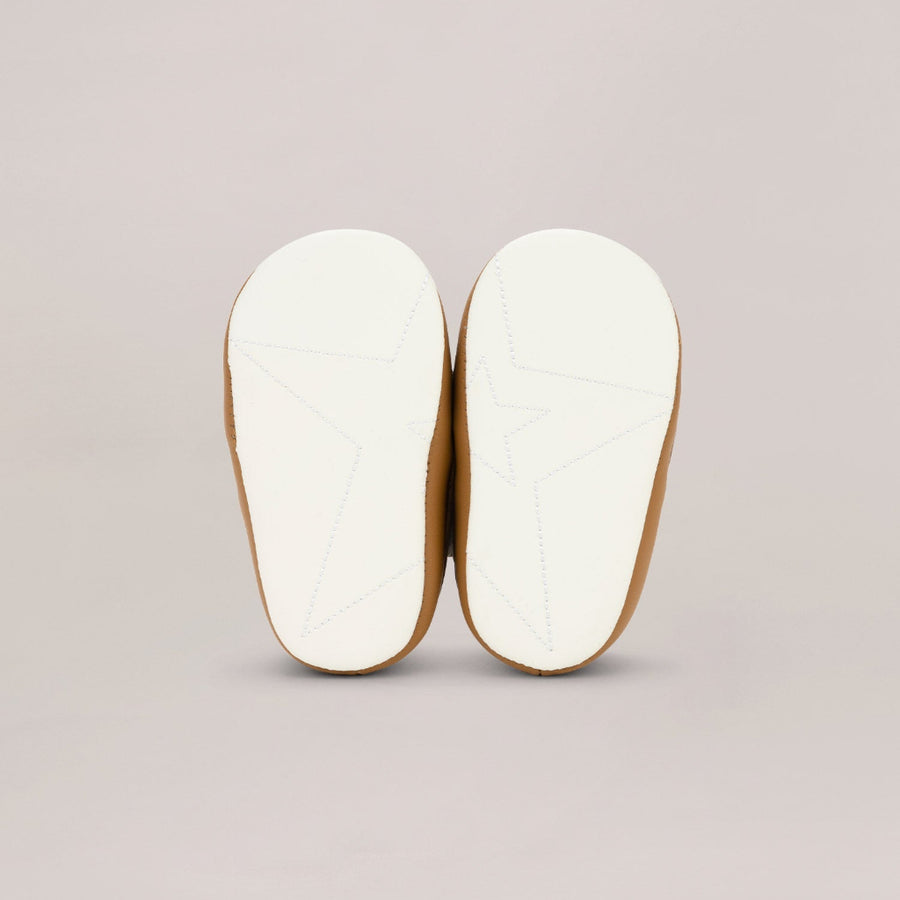 Pair of white soled shoes on a light gray background