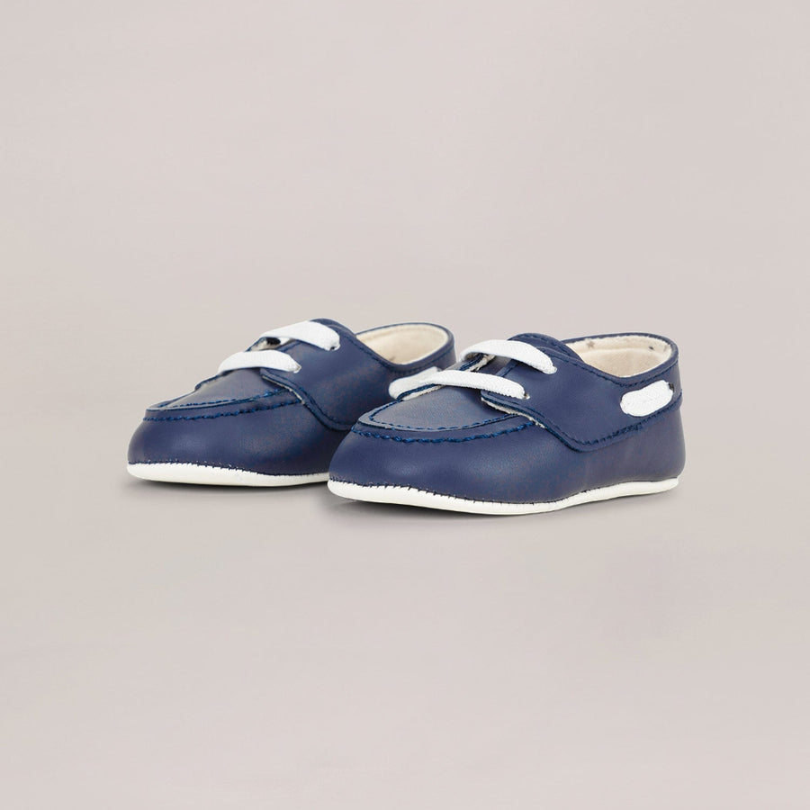 Pair of navy blue shoes with white soles on a light gray background