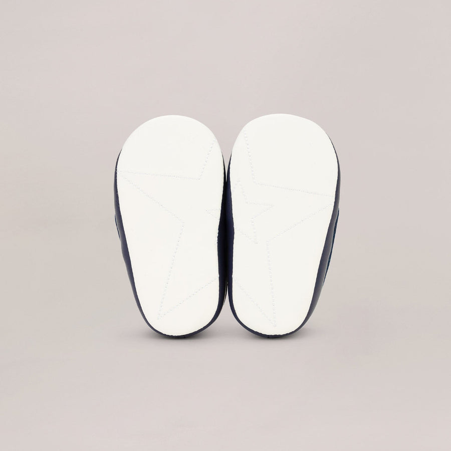 Two white soled shoes with black edges on a light gray background