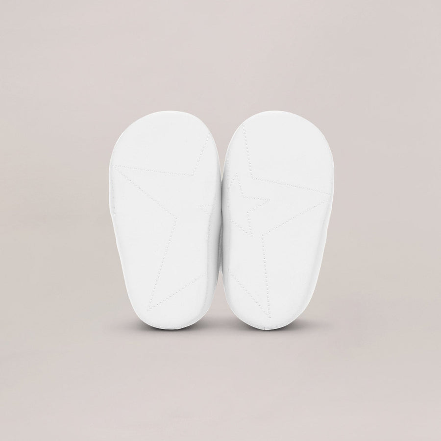 Pair of white soled shoes on a beige background