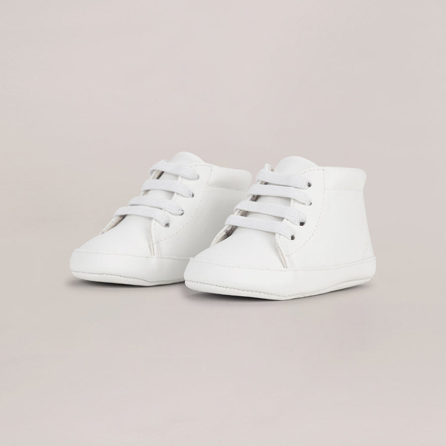 Pair of white high-top sneakers on a light gray background