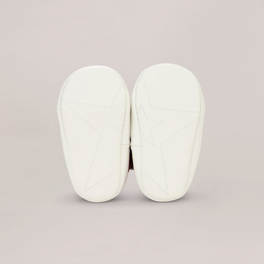 Pair of white soled shoes on a light gray background