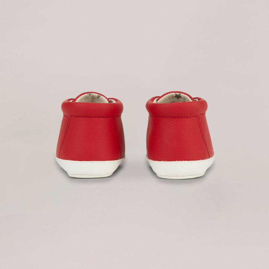 Pair of red high-top shoes on a light gray background