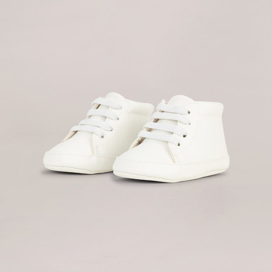 Pair of white high-top sneakers on a light gray background