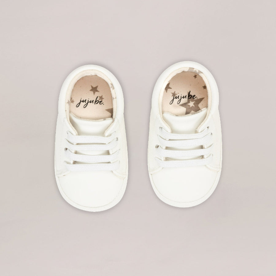 Pair of white sneakers with 'juu:be' branding on a light gray background