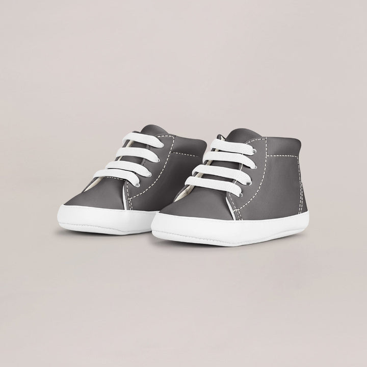 Pair of gray high-top sneakers with white laces on a light gray background