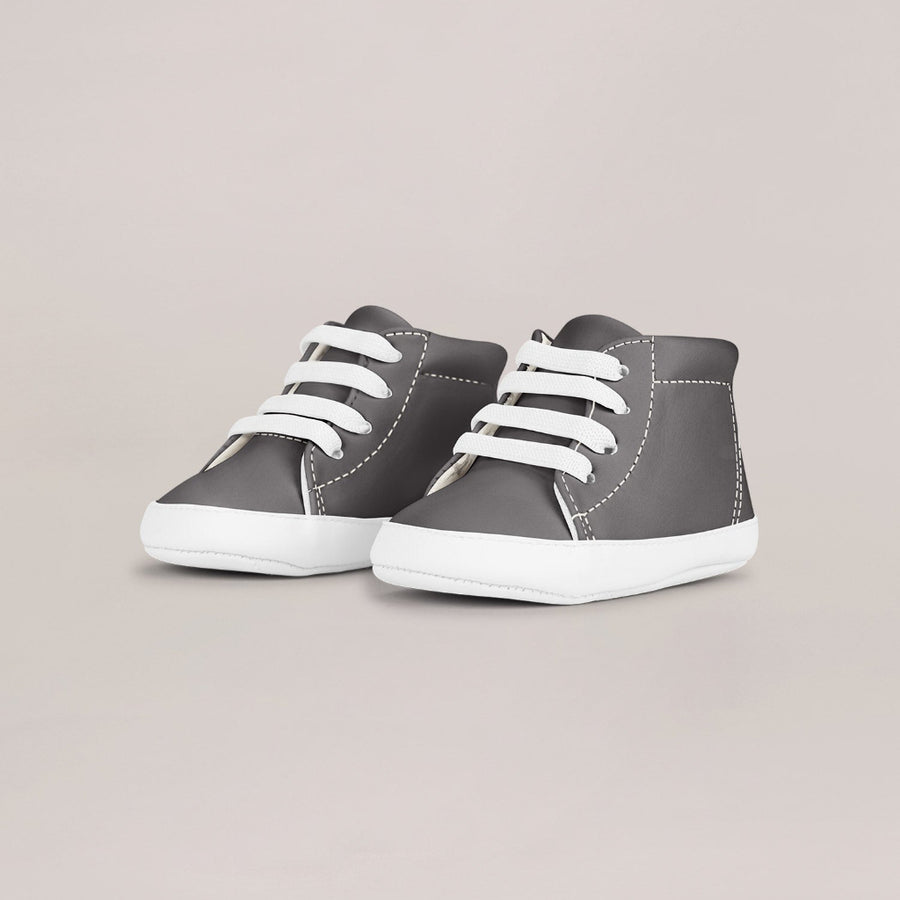 Pair of gray high-top sneakers with white laces on a light gray background