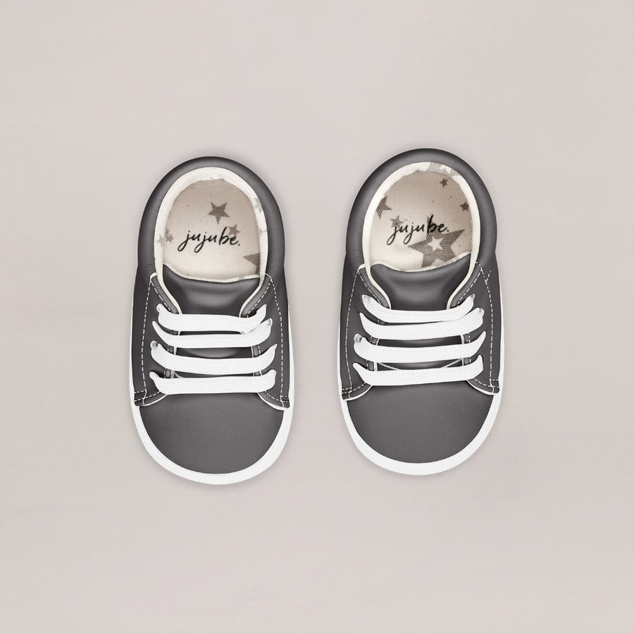 Pair of gray sneakers with white soles on a light gray background