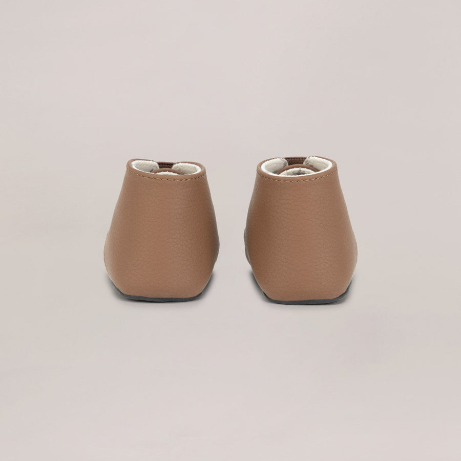 Pair of brown leather shoes on a light gray background