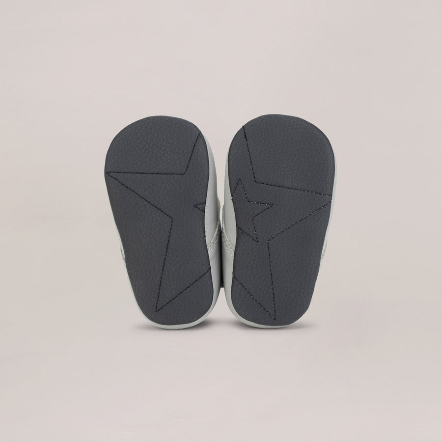 Pair of black soled shoes on a light gray background