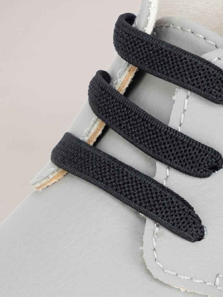 Black elastic shoelaces on a light gray shoe