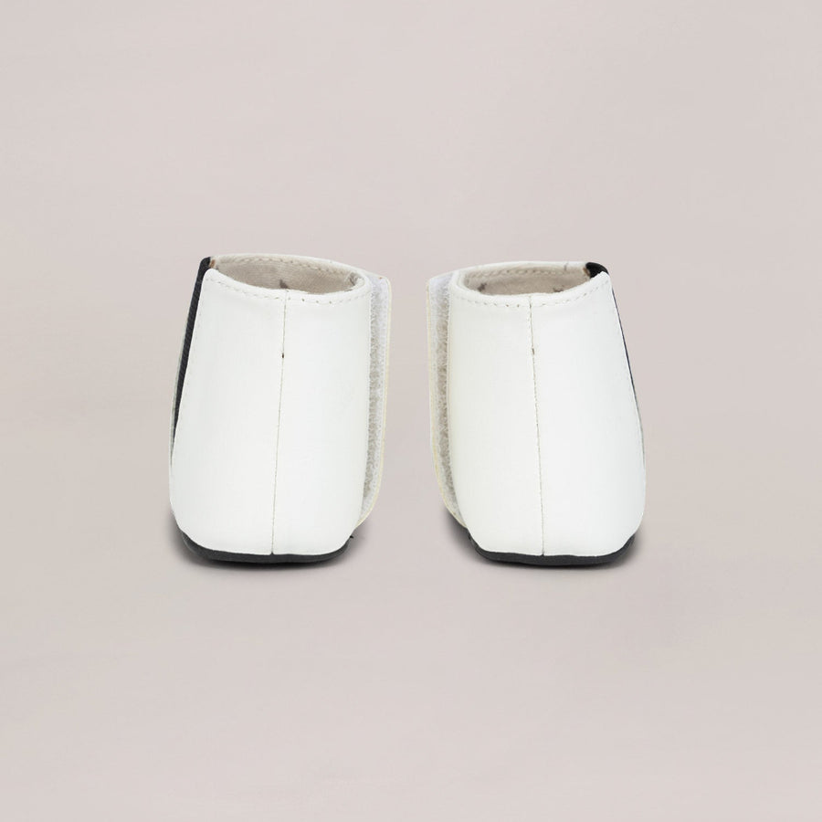 Pair of white shoes with black accents on a light gray background