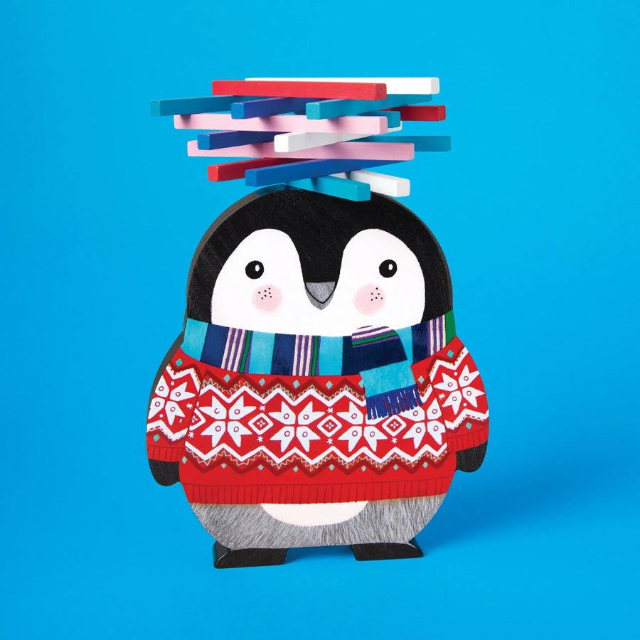 Penguin wearing a red sweater and striped scarf with stacked pieces on its head against a blue background