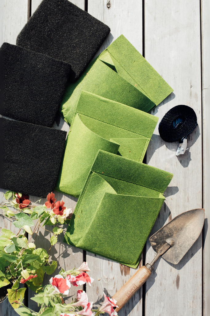 Green and black cloths on a wooden surface with gardening tools