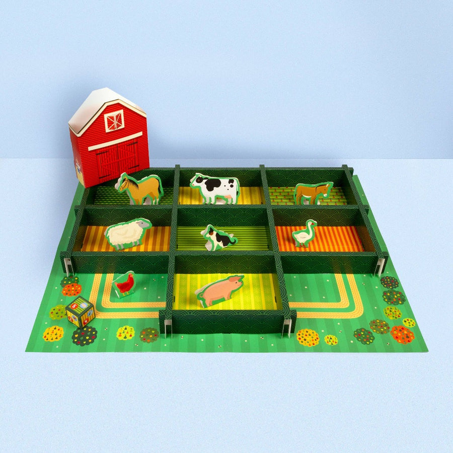 Image of the assembled playset on a light blue surface against a light blue wall, taken from an angle so that you can see the height of the hedges separating the squares with different animals in each one.