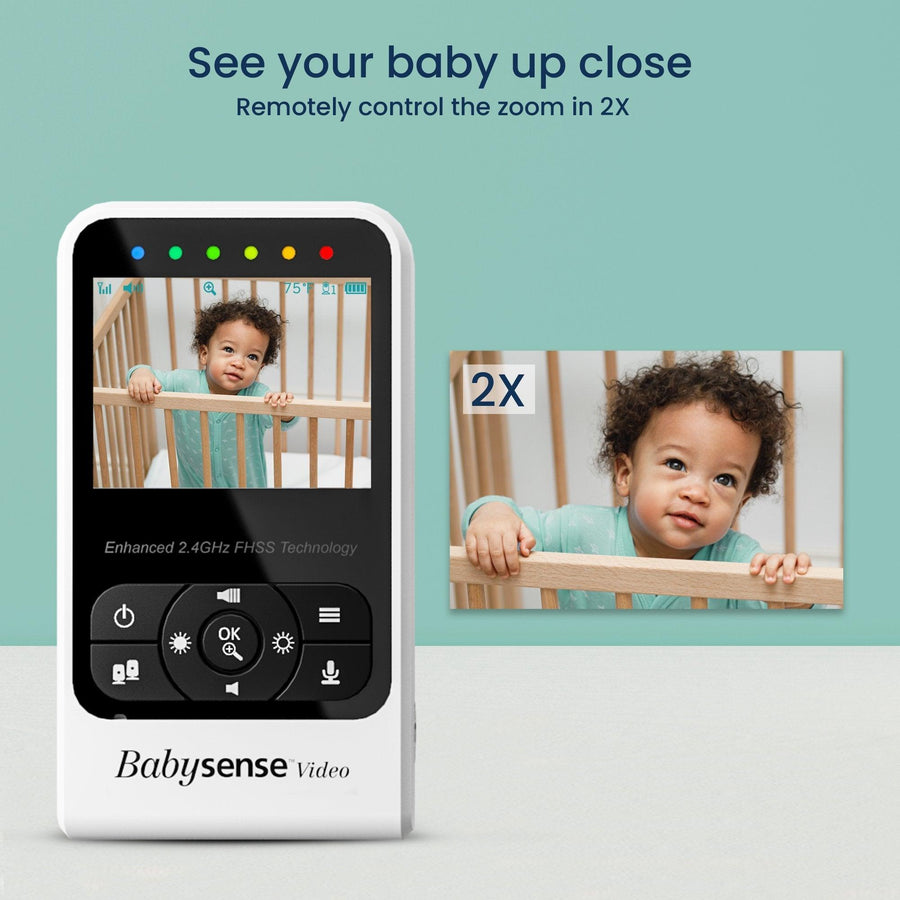 Image of the baby monitor screen showing a baby standing in a crib looking at the camera, with another image on the right showing a close up of the baby, labeled 2X. Text reads, 