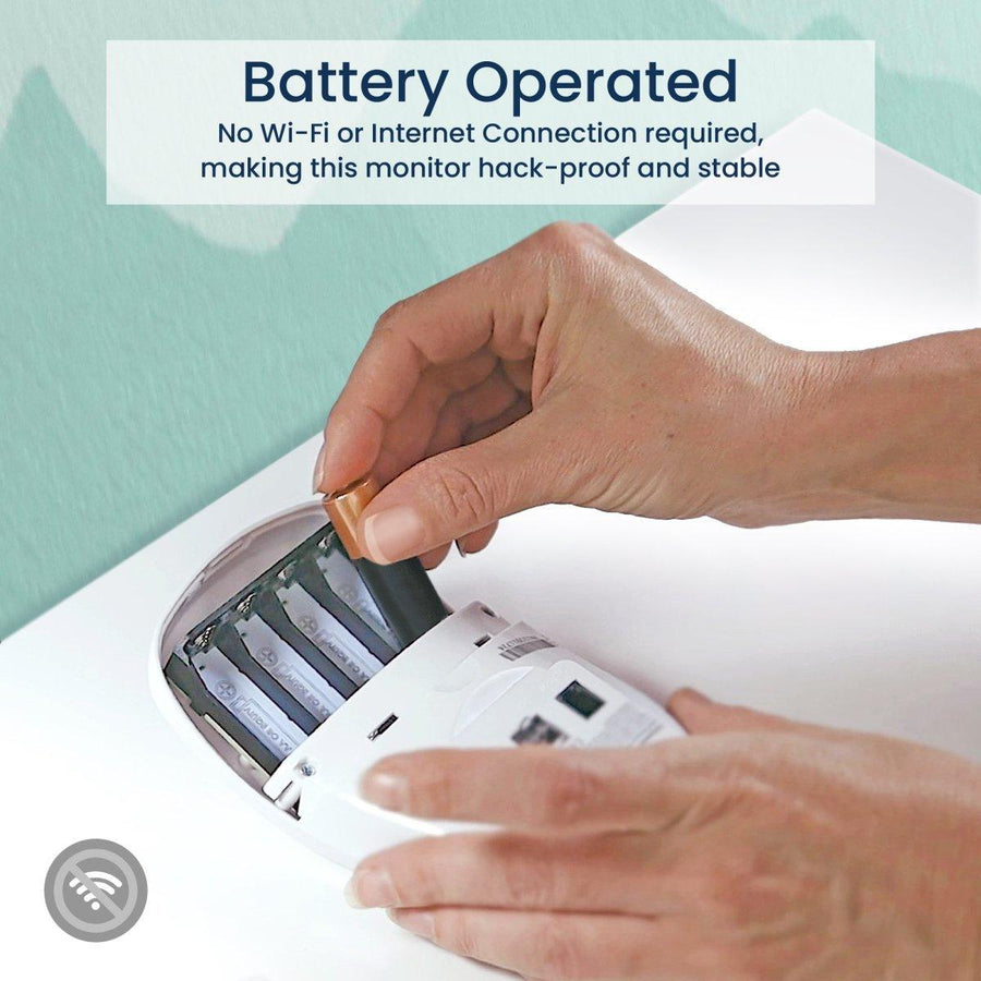 Image of a person's hands installing AA batteries in the baby monitor. Text reads, 