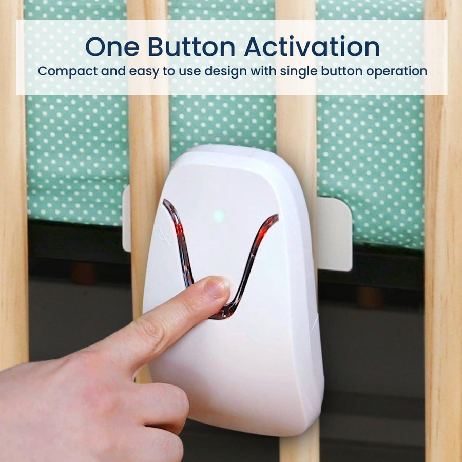 Close up of the monitor installed on a crib with a person's finger pressing the button. Image reads, 