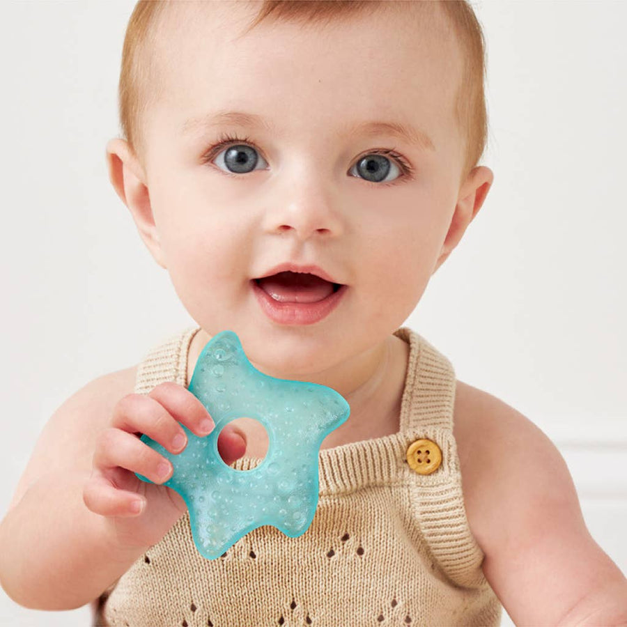 Baby holding a blue star-shaped teething toy against a plain background