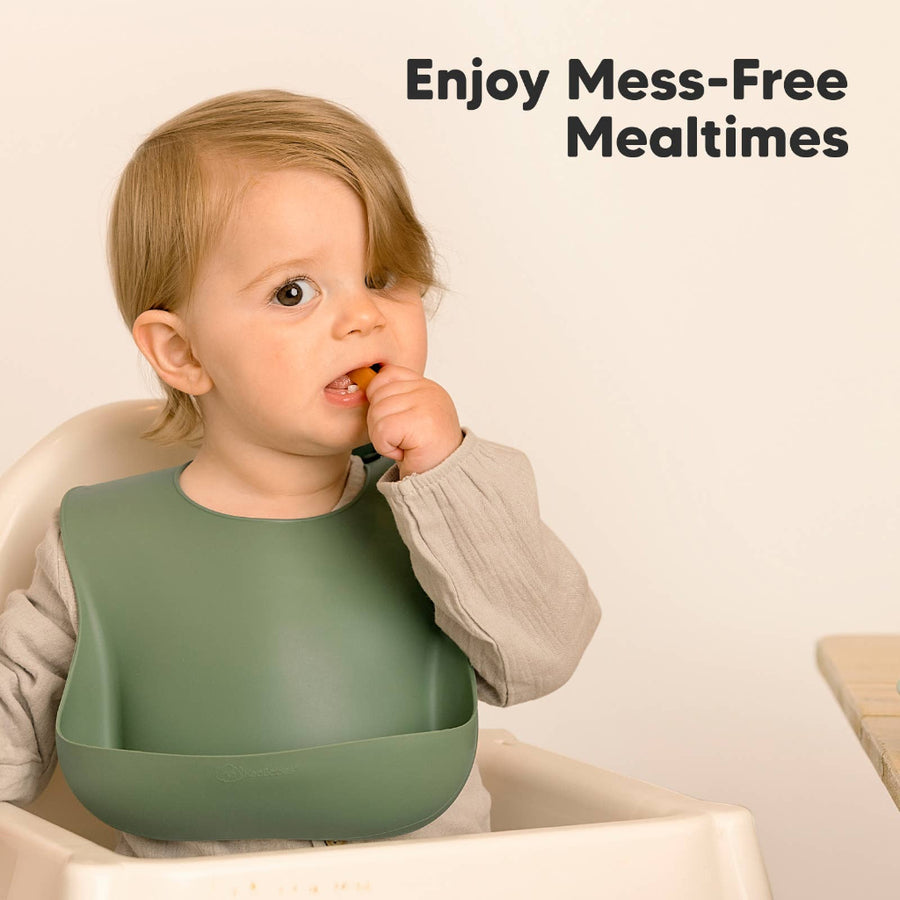 Child wearing a green bib with text 'Enjoy Mess-Free Mealtimes' on a beige background