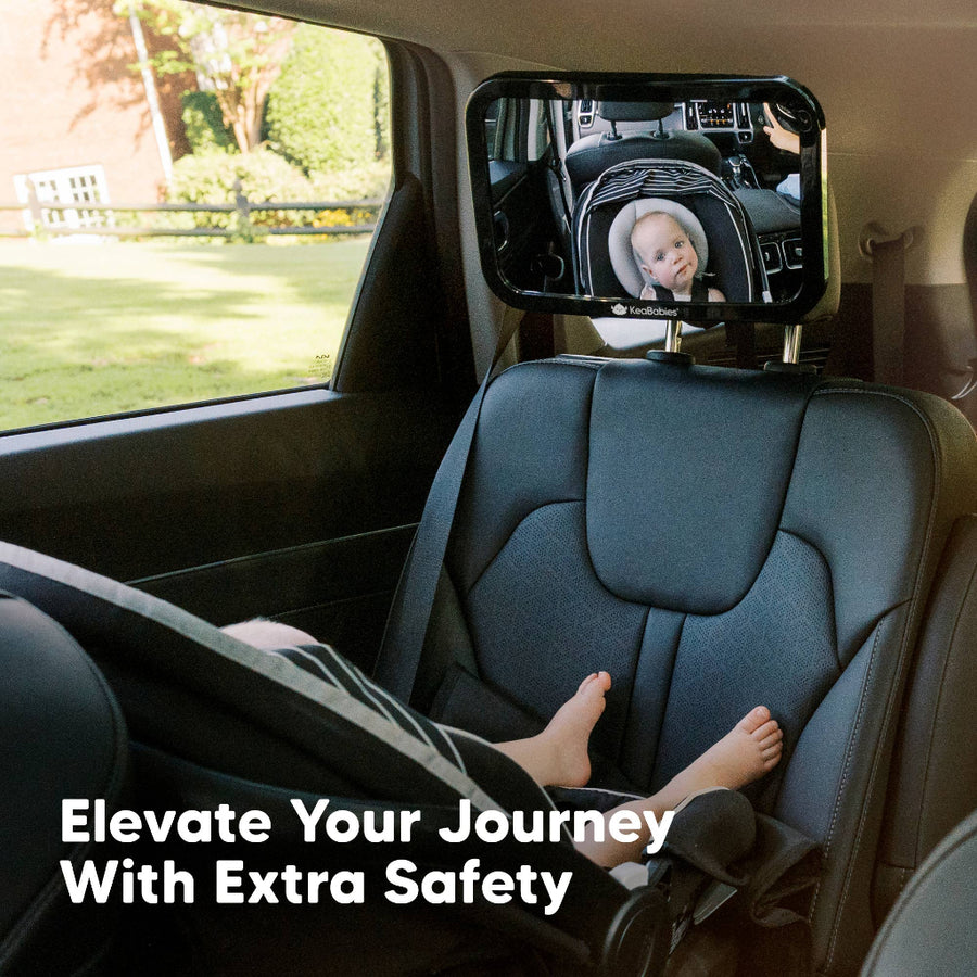 Car seat with a baby monitor attached, showing a child in a car seat through a mirror.
