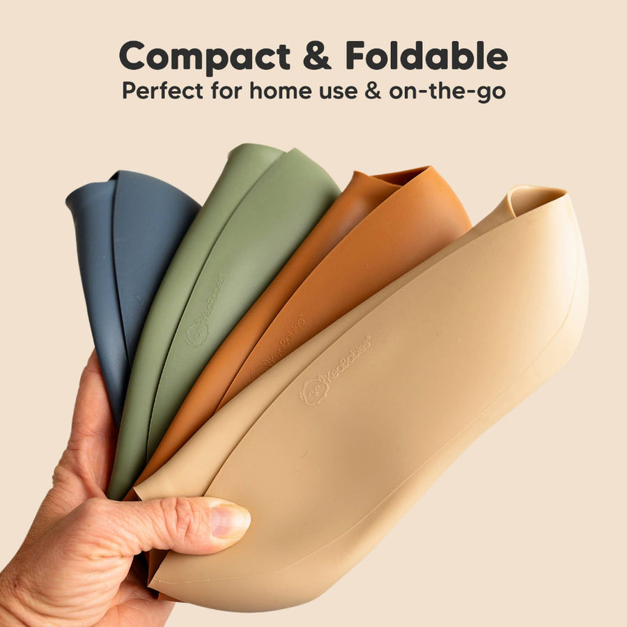Foldable bibs in various colors held by a hand with text about compactness and portability.