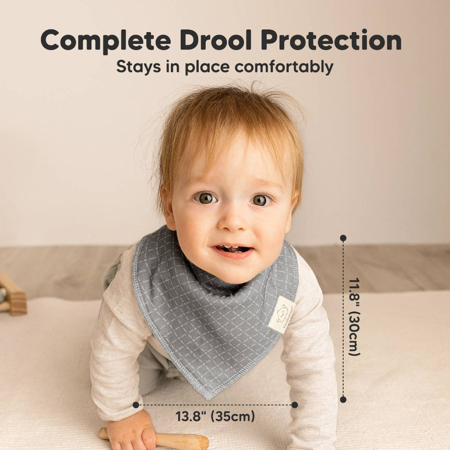 Baby wearing a gray bib with text about drool protection and dimensions.