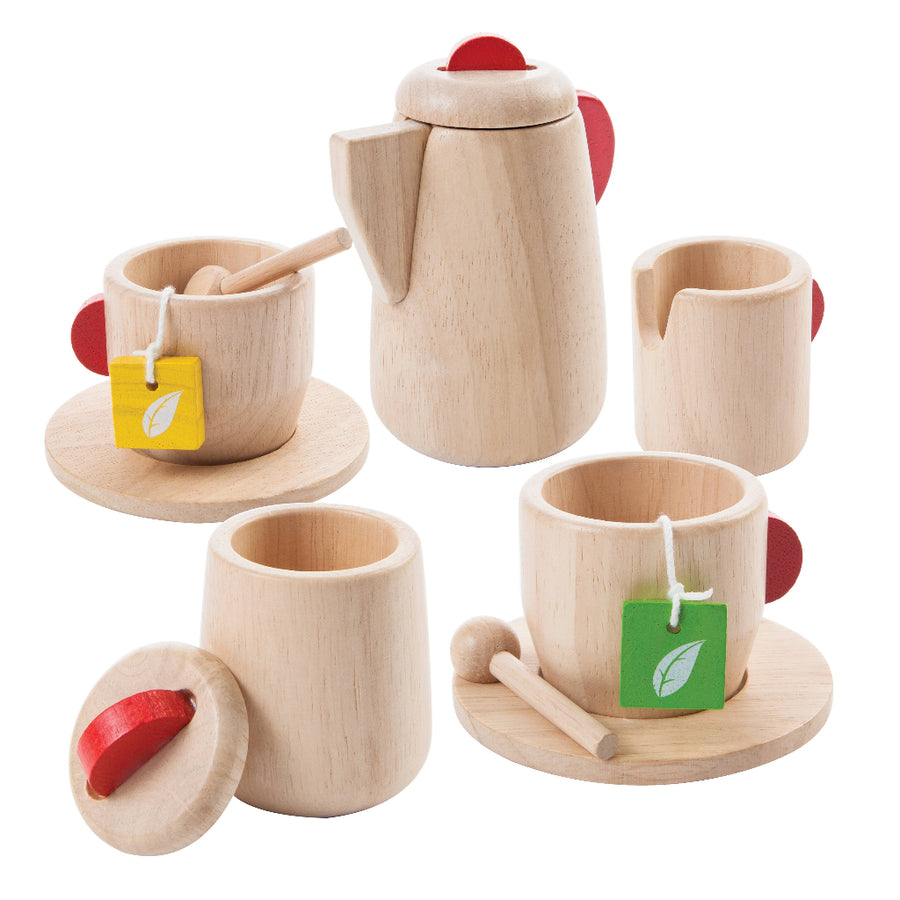 Wooden toy tea set with teapot, cups, and saucers on a white background
